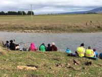 Lunch at the Taieri River. Sheltering as much as possible from the cold Nor-wester.